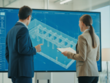 Two professionals discussing a dredge system blueprint on a screen, representing the selection of a dredge manufacturer.